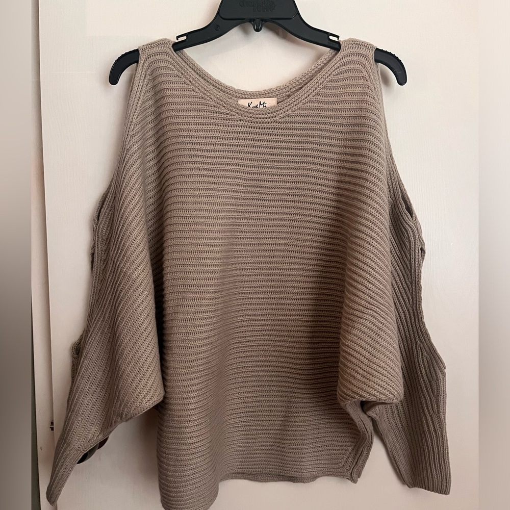 Scoop neck sweater with side opening on each sleeve.